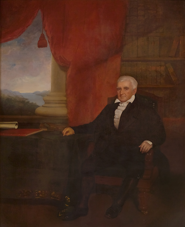 Old portrait of a white haired man seated before a draped window