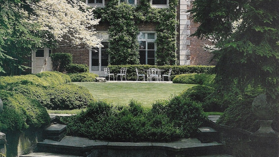 outdoor garden with stone steps behind a stately brick building